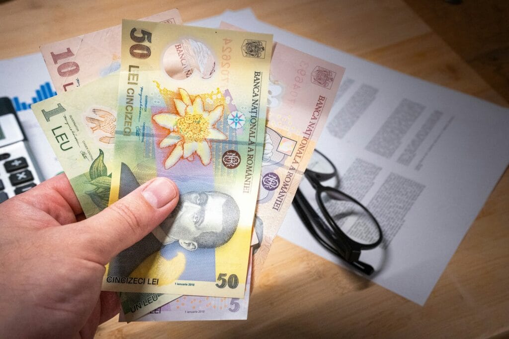 человек держит купюру Левы болгарии - Страна с которой есть налоговое соглашение со Швейцарией