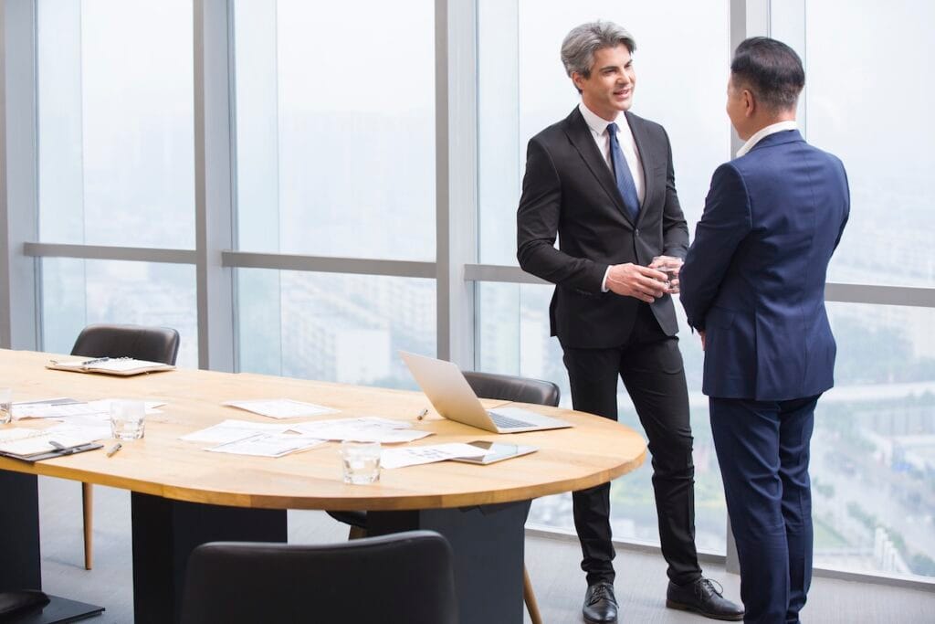 Банковский консультант общается с нерезидентом в офисе — иллюстрация услуги «открыть счет в иностранном банке нерезиденту», индивидуальная консультация, комплаенс-проверка и сопровождение клиента.